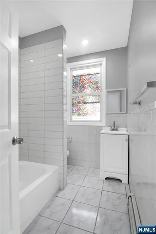 a bathroom with a bathtub a sink and a window