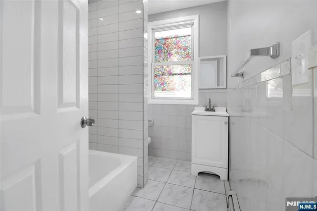 a bathroom with a sink a bathtub and window