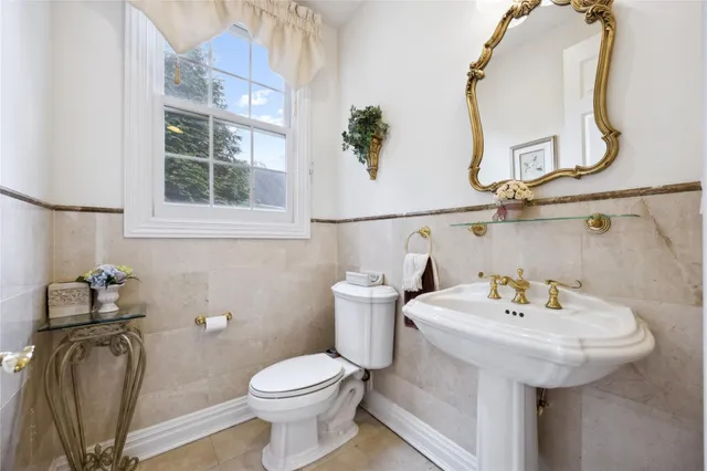 a bathroom with a sink a toilet and a mirror