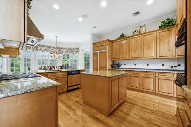 a kitchen with stainless steel appliances granite countertop a stove a sink and a microwave