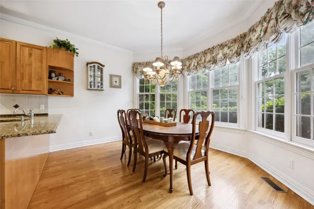 a dining room with furniture a chandelier and wooden floor