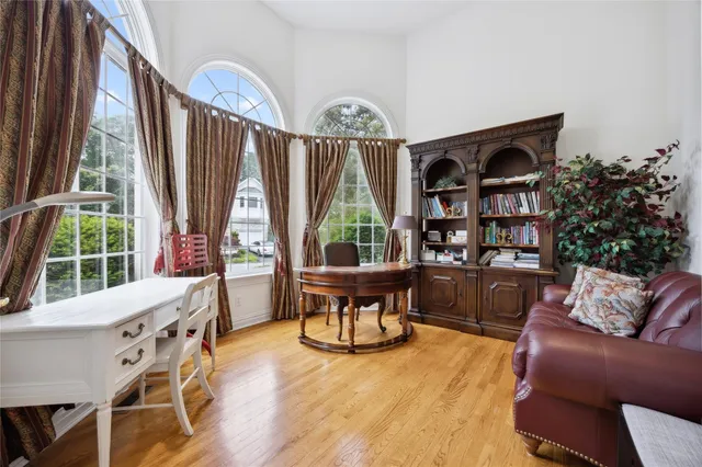 a living room with furniture a window and wooden floor