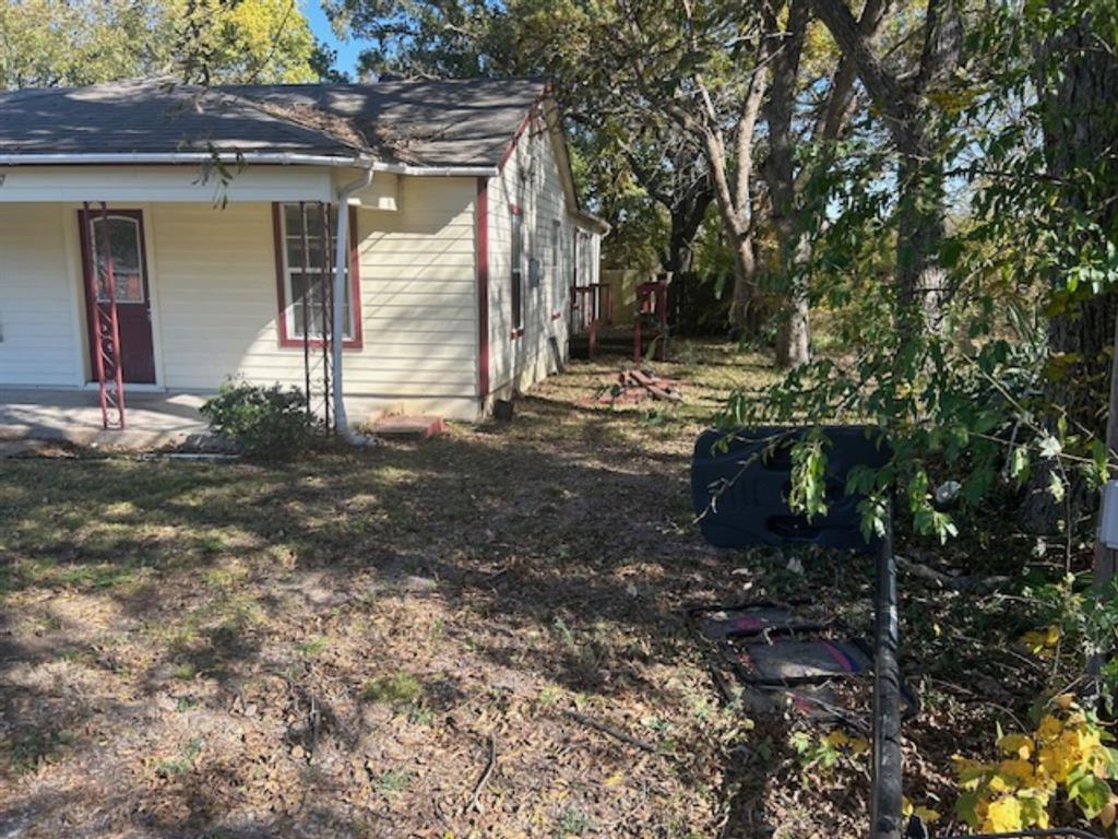 307 South Jernigan Street Bells, TX 75414 - Photo 3 of 10 a backyard of a house with yard and outdoor seating