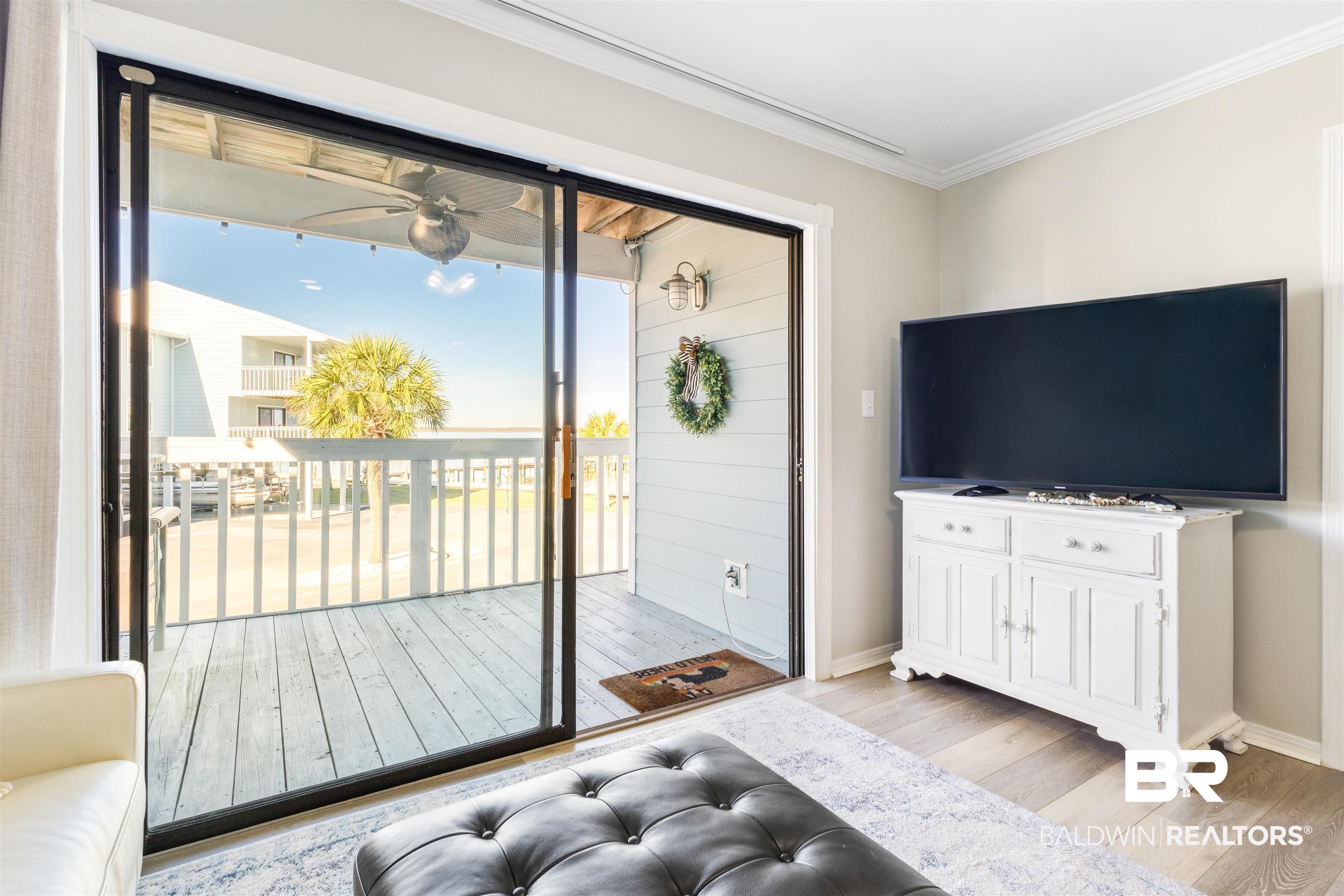 25861 Canal Road, Unit 3 Orange Beach, AL 36561 - Photo 13 of 40 Living area with crown molding, light wood-style floors, and ceiling fan