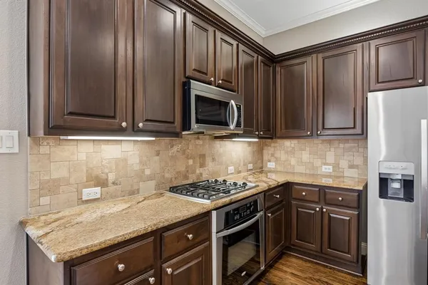 a kitchen with granite countertop a sink stove and refrigerator