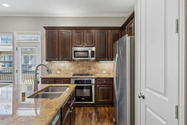 a kitchen with stainless steel appliances granite countertop a stove and a refrigerator