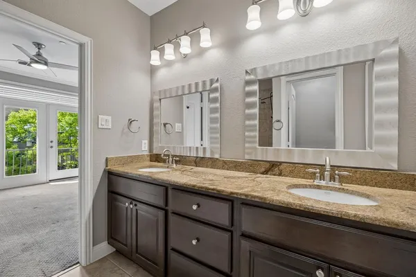 a bathroom with a granite countertop bathtub shower and cabinets