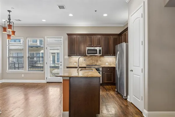a kitchen with stainless steel appliances granite countertop a sink stove and refrigerator