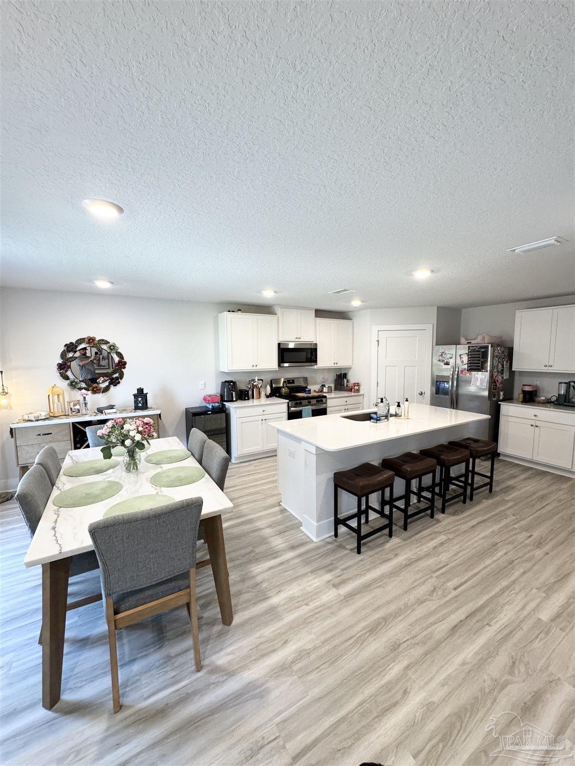 3315 Garganey Road Pace, FL 32571 - Photo 12 of 52 a living room with stainless steel appliances kitchen island granite countertop furniture and a wooden floor