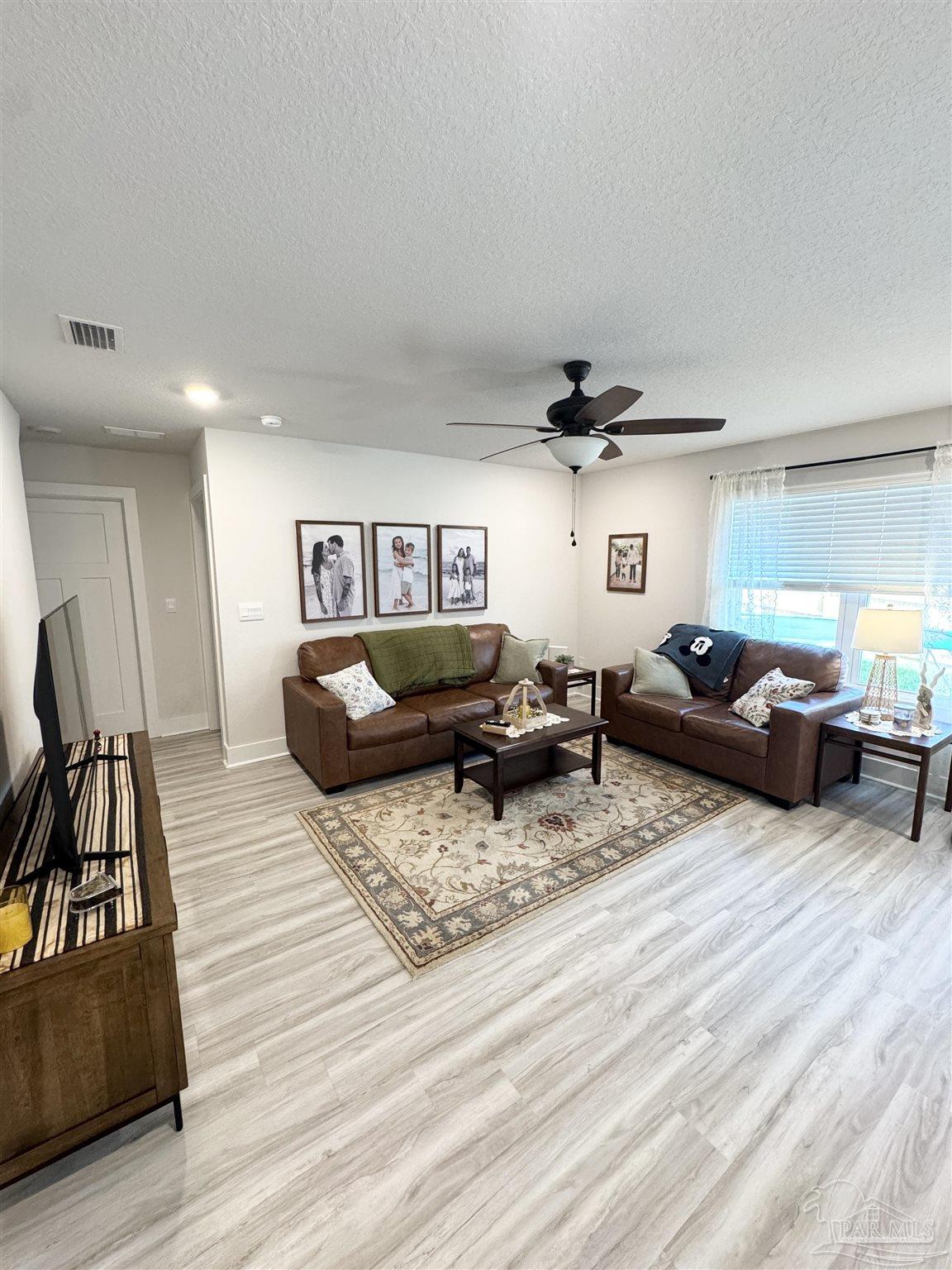 3315 Garganey Road Pace, FL 32571 - Photo 13 of 52 a living room with furniture and a wooden floor