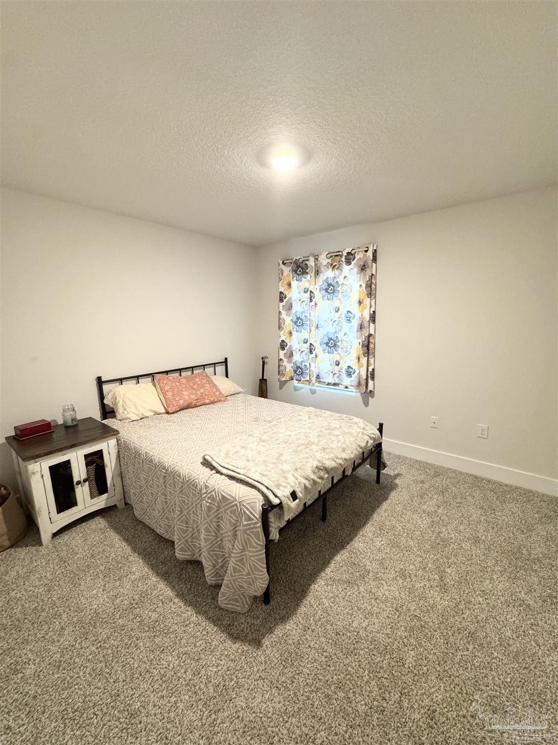 3315 Garganey Road Pace, FL 32571 - Photo 14 of 52 a spacious bedroom with a bed and a window