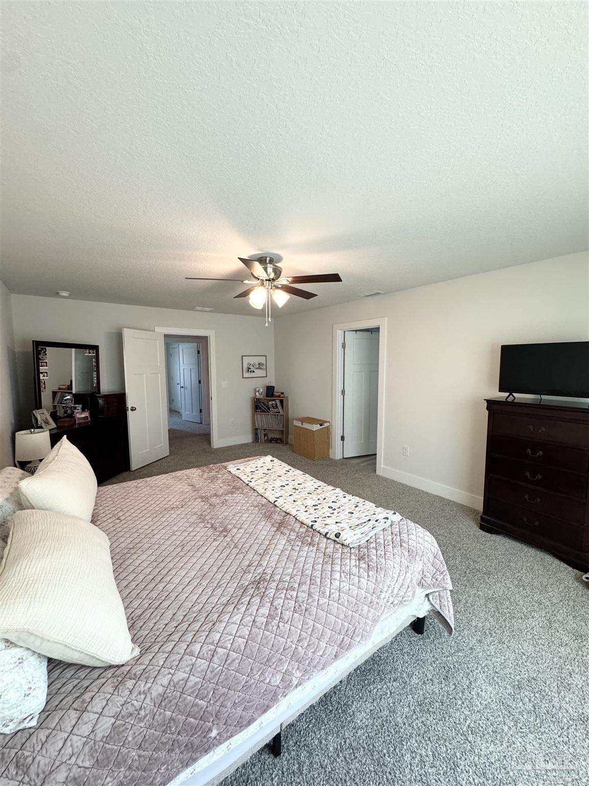 3315 Garganey Road Pace, FL 32571 - Photo 24 of 52 a bedroom with a bed and dresser with mirror