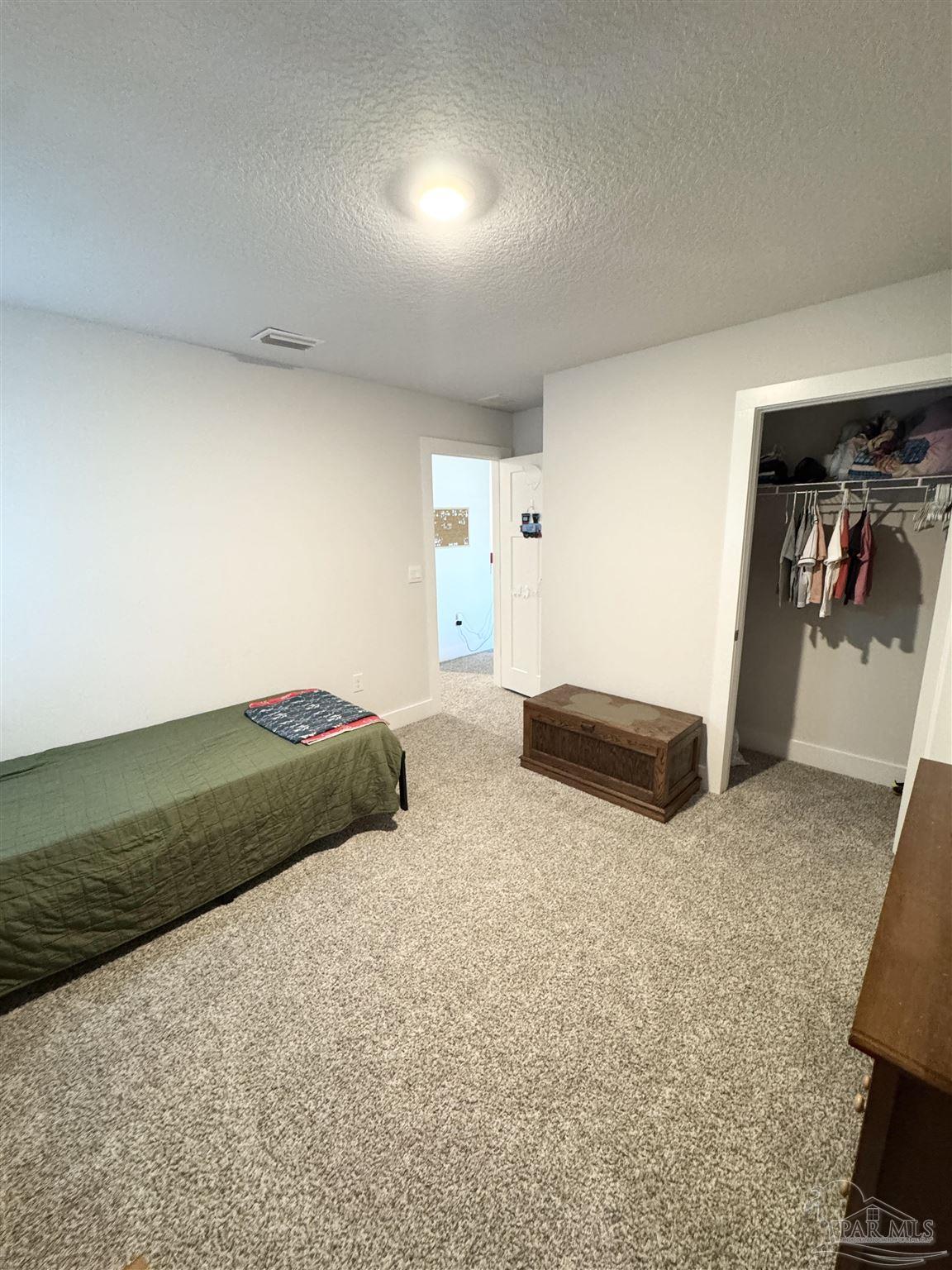 3315 Garganey Road Pace, FL 32571 - Photo 30 of 52 a bedroom with a bed and a view of living room