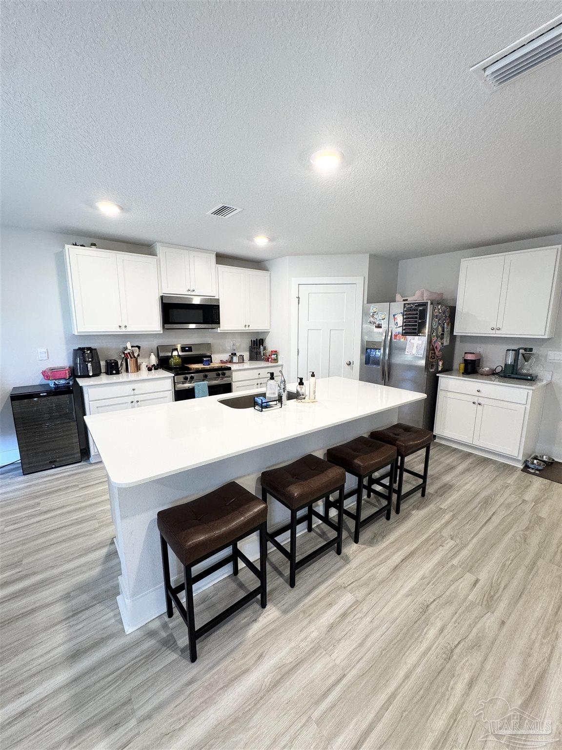 3315 Garganey Road Pace, FL 32571 - Photo 8 of 52 a kitchen with stainless steel appliances a stove a sink a microwave a refrigerator and cabinets