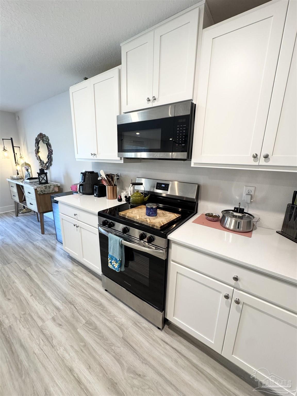 3315 Garganey Road Pace, FL 32571 - Photo 9 of 52 a kitchen with a stove and a white cabinets