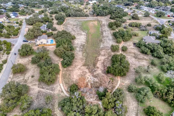 an aerial view of residential house with outdoor space and trees all around