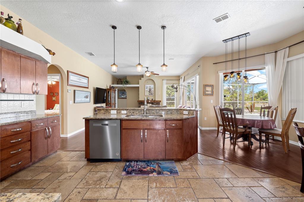 3051 Waterfall Drive Spring Hill, FL 34608 - Photo 12 of 74 a kitchen with stainless steel appliances granite countertop a stove a sink a oven with a dining table and chairs
