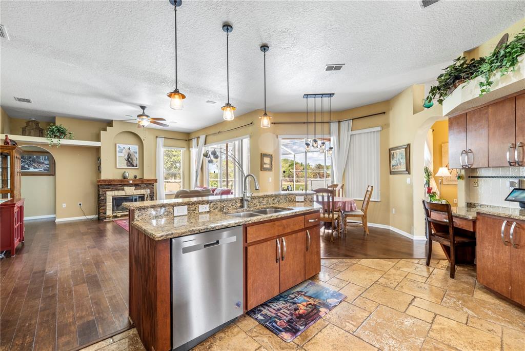 3051 Waterfall Drive Spring Hill, FL 34608 - Photo 13 of 74 a kitchen with stainless steel appliances granite countertop a stove and a view of dining hall with wooden floor