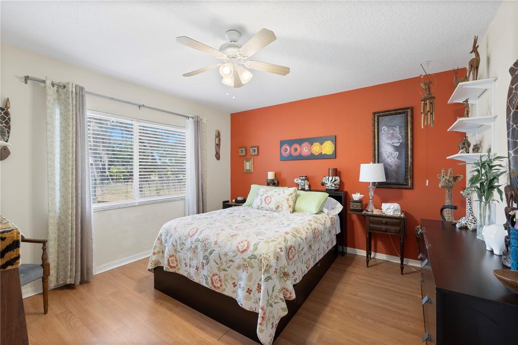 3051 Waterfall Drive Spring Hill, FL 34608 - Photo 30 of 74 a bedroom with a large bed and a chandelier