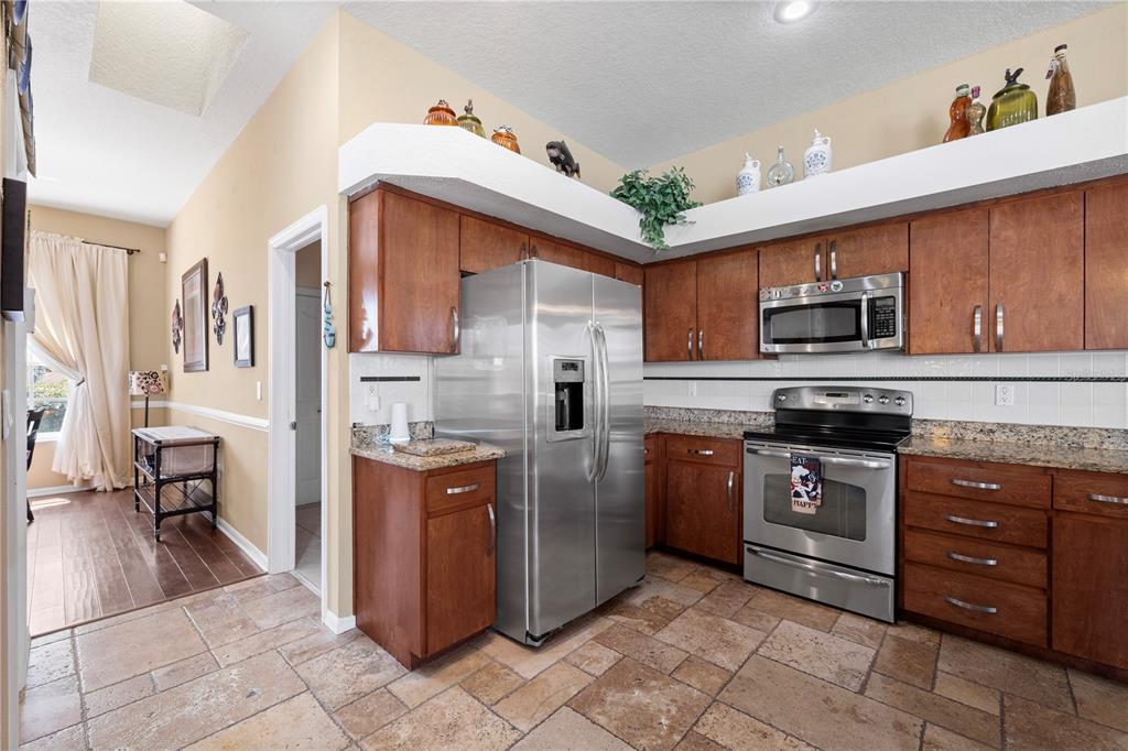 3051 Waterfall Drive Spring Hill, FL 34608 - Photo 59 of 74 a kitchen with stainless steel appliances granite countertop a stove and a sink
