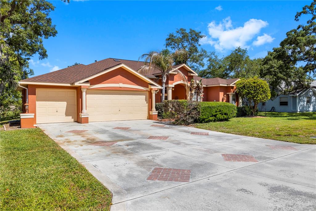 3051 Waterfall Drive Spring Hill, FL 34608 - Photo 73 of 74 a front view of a house with a yard and garage