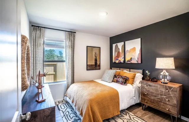 a bedroom with a bed and large windows