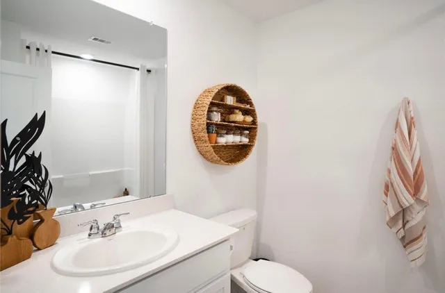 a bathroom with a sink toilet and a mirror