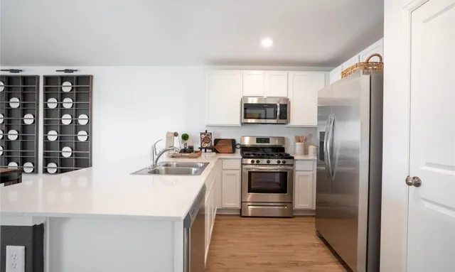 a kitchen with stainless steel appliances granite countertop a refrigerator sink and stove