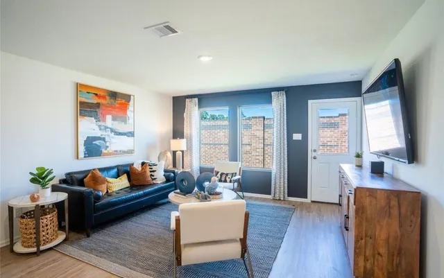 a living room with furniture and wooden floor