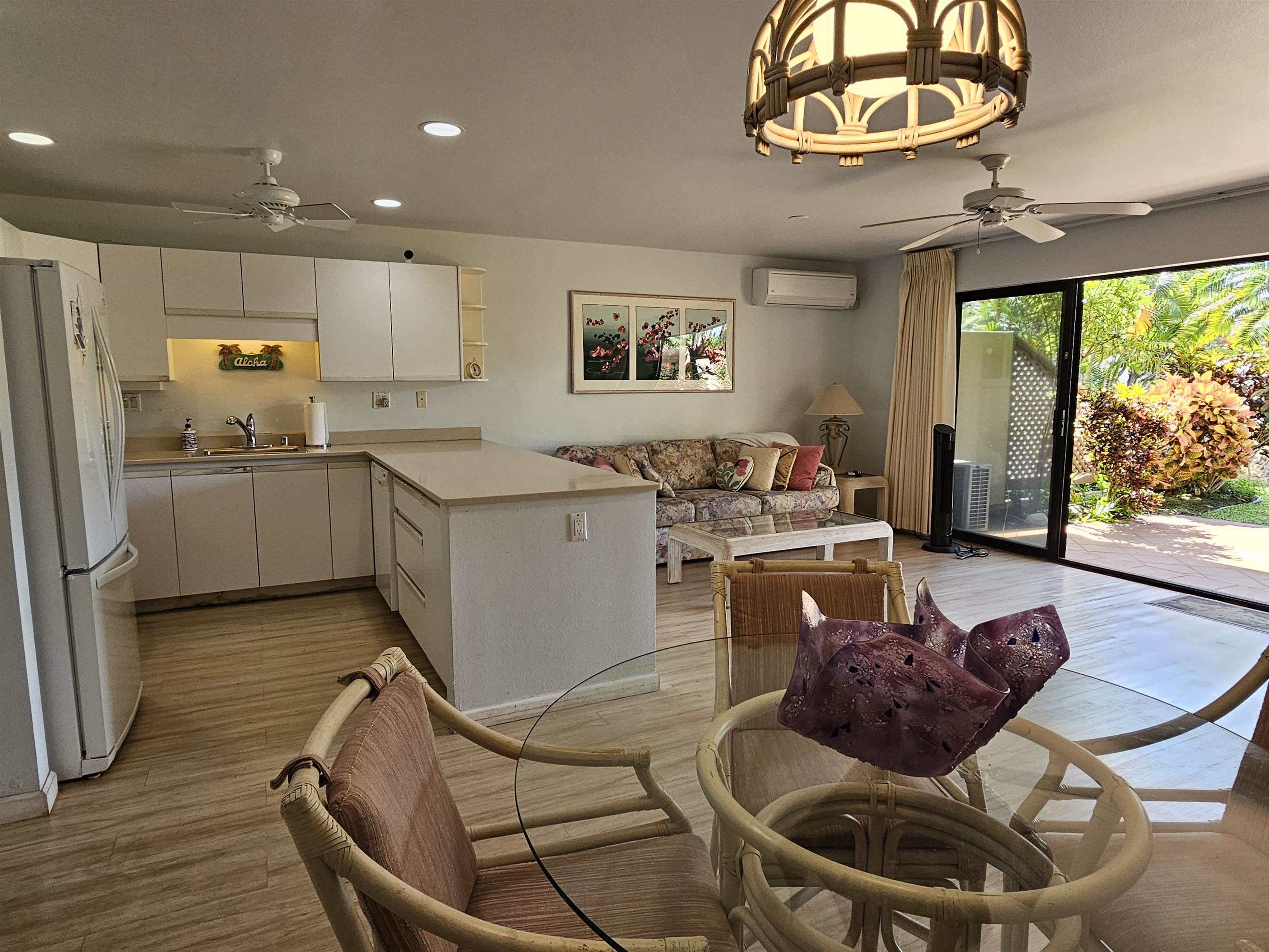 2777 South Kihei Road, Unit K107 Kihei, HI 96753 - Photo 20 of 50 a kitchen with stainless steel appliances granite countertop a stove a refrigerator a microwave oven with a dining table and chairs with wooden floor