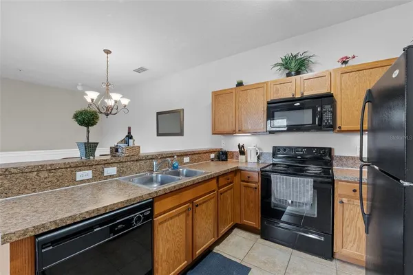 a kitchen with kitchen island granite countertop a sink stove and refrigerator