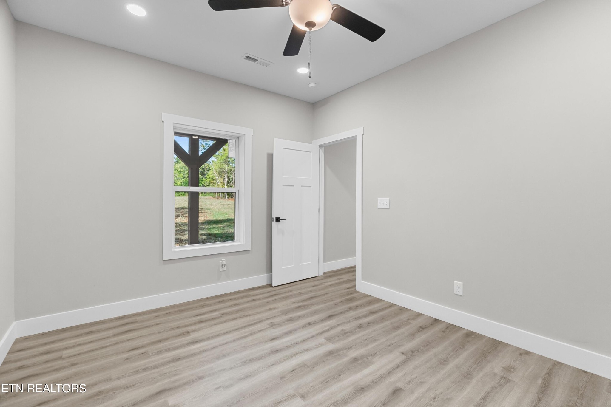 146 Fancher Road Newport, TN 37821 - Photo 23 of 41 an empty room with wooden floor chandelier fan and windows