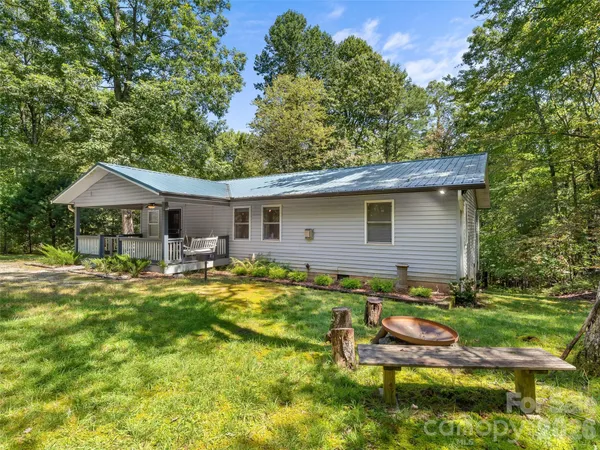 a backyard of a house with yard table and chairs
