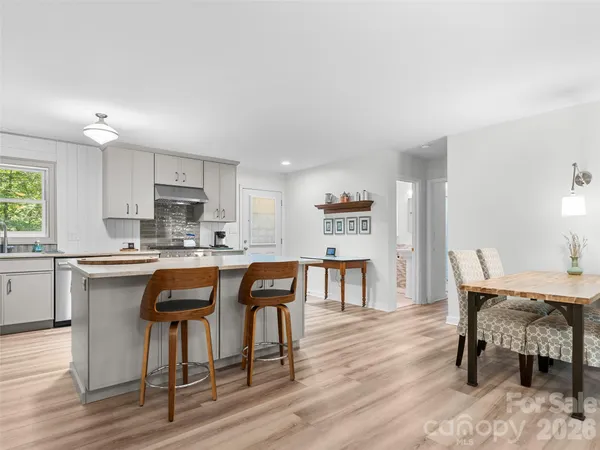 a kitchen with stainless steel appliances kitchen island hardwood floor sink and stove