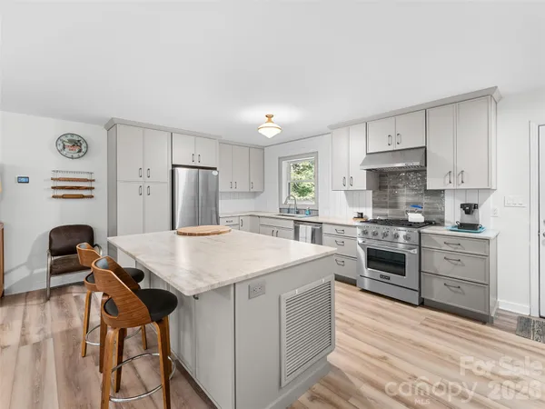 a kitchen with a stove a refrigerator and a stove top oven