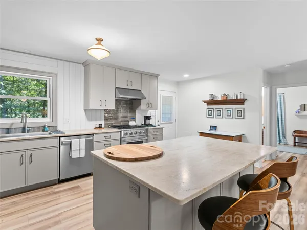 a kitchen with a table chairs sink and cabinets