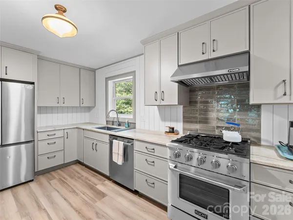 a kitchen with cabinets stainless steel appliances and a window