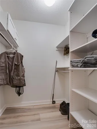 a view of walk in closet with clothes and shoes