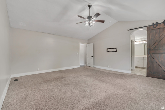 2154 Wasatch Boulevard Sandy, UT 84092 - Photo 14 of 55 Unfurnished bedroom with a barn door, lofted ceiling, light colored carpet, ceiling fan, and ensuite bathroom