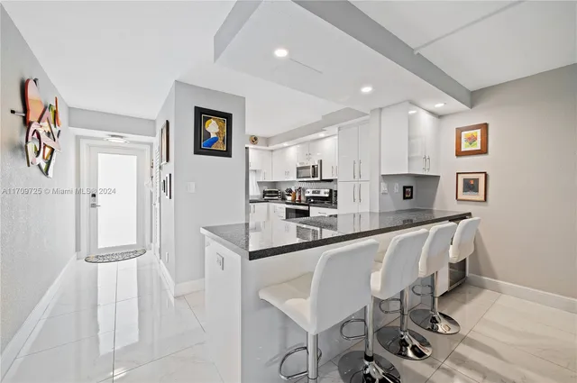 a kitchen with stainless steel appliances granite countertop a refrigerator and a stove top oven
