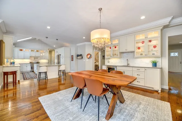 a kitchen with stainless steel appliances a dining table chairs and wooden floor