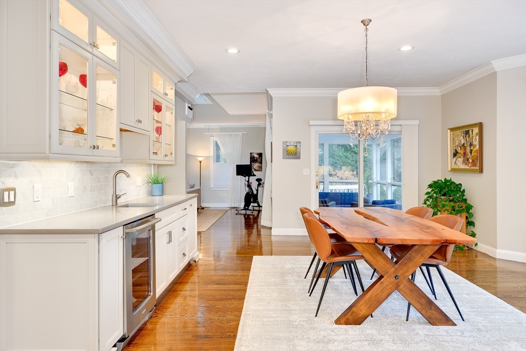 22 Forest Lane, Unit 22 Scituate, MA 02066 - Photo 6 of 27 a kitchen with stainless steel appliances kitchen island granite countertop a table chairs in it and wooden floors