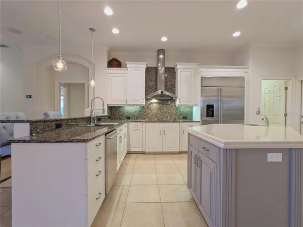 a kitchen with stainless steel appliances granite countertop a sink and a refrigerator