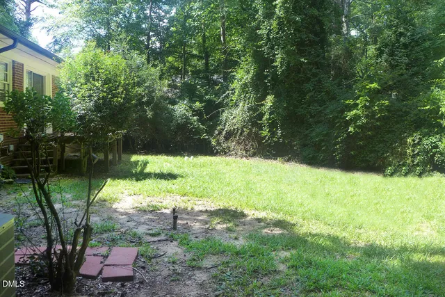 a view of a backyard with a garden and entertaining space