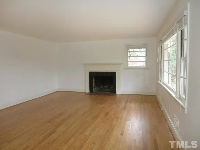 wooden floor fireplace and windows in an empty room