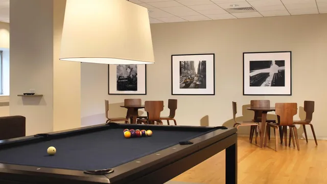 a living room with furniture pool table and window