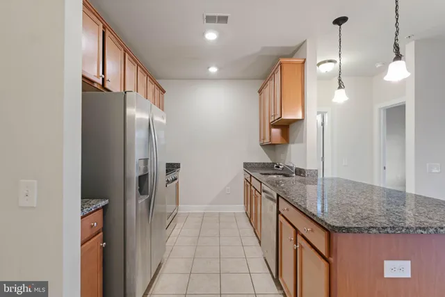 a kitchen with granite countertop a refrigerator and a sink