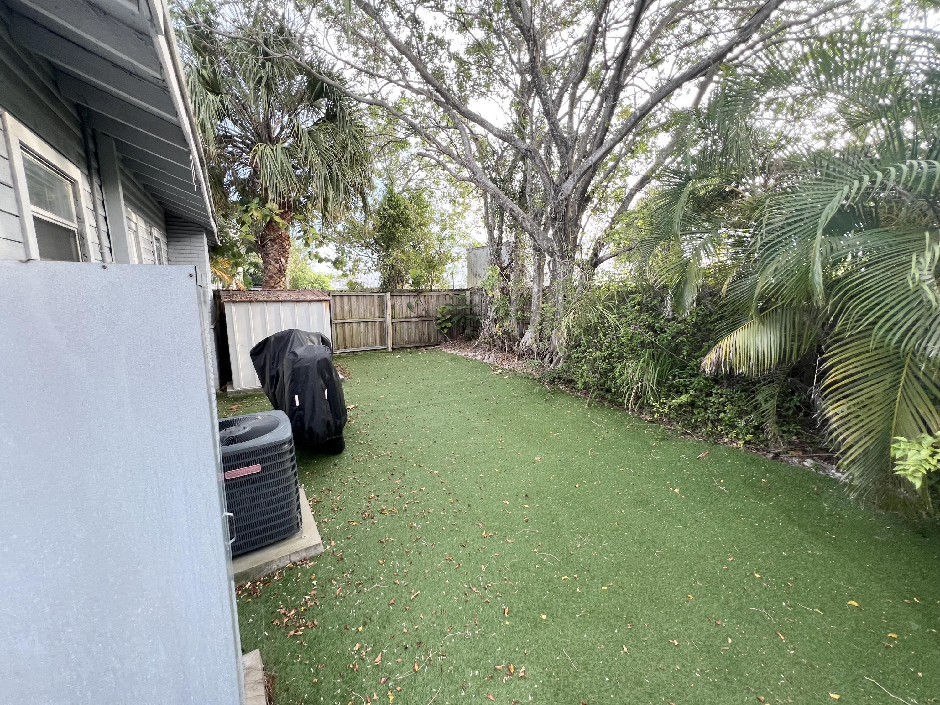 431 Ardmore Road West Palm Beach, FL 33401 - Photo 13 of 13 a view of a backyard with couches under an umbrella with large trees