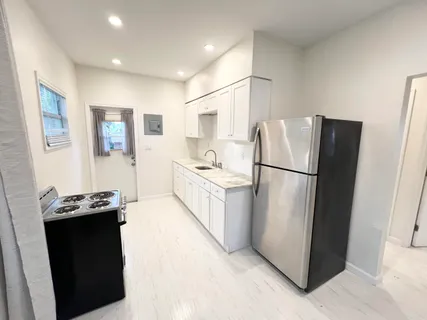 a kitchen with stainless steel appliances granite countertop a refrigerator a stove a sink and a refrigerator