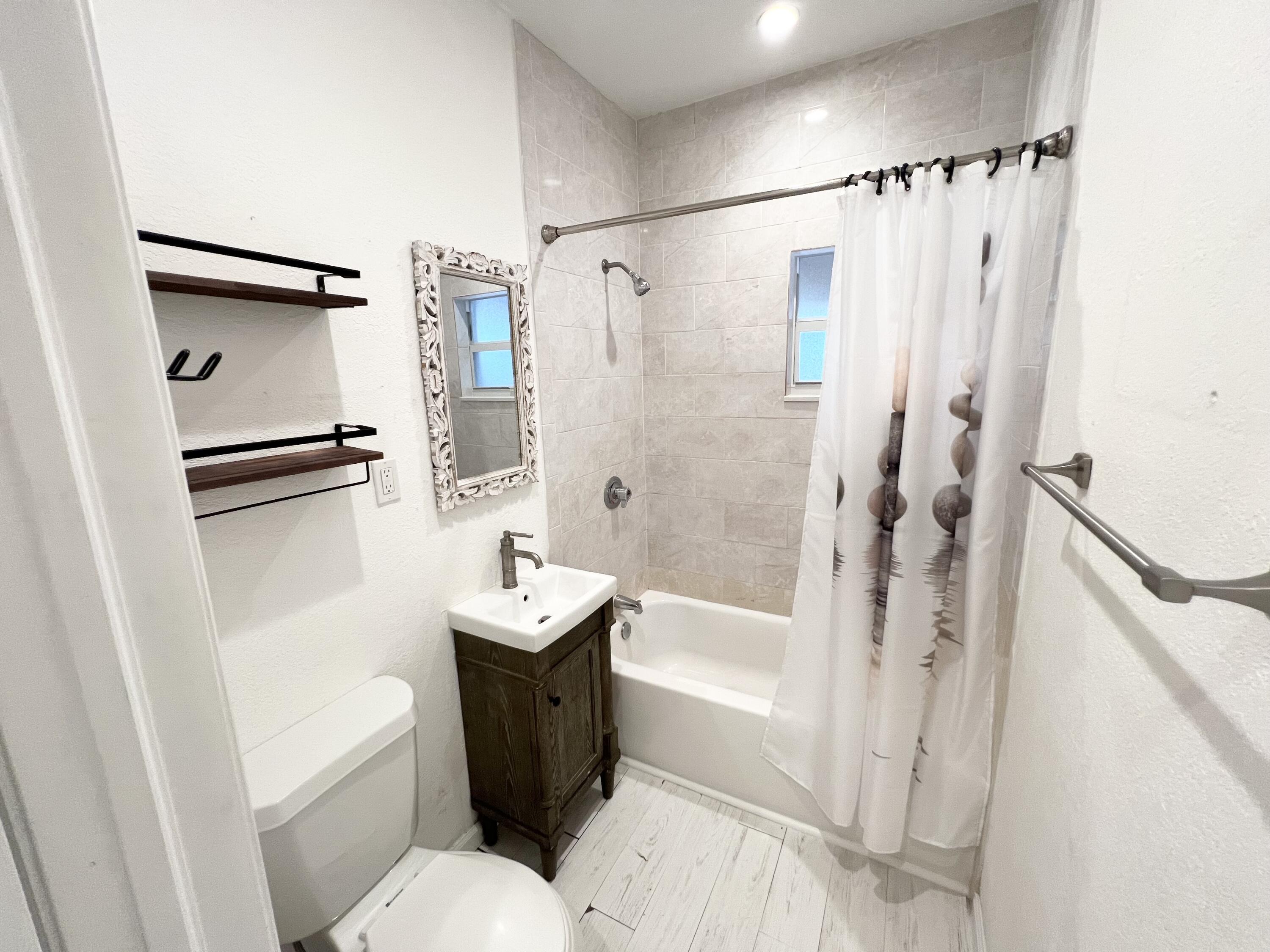 431 Ardmore Road West Palm Beach, FL 33401 - Photo 10 of 13 a bathroom with a sink a toilet a mirror a vanity and shower